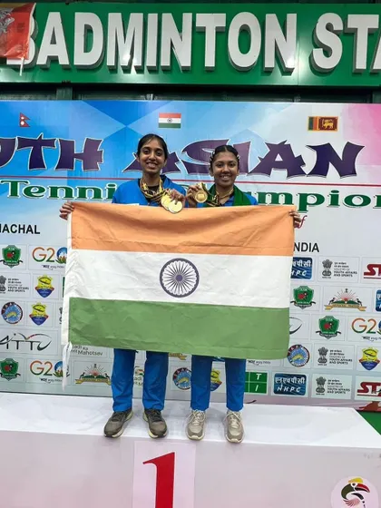 Yashaswini and her doubles partner on the top of the podium with their gold medals.
