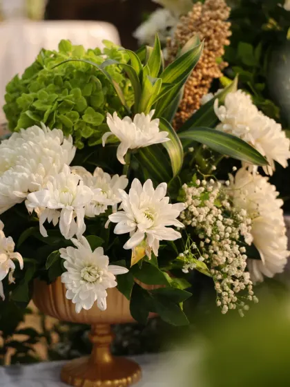 Another angle of the white and green floral arrangement, highlighting the delicate baby's breath and the elegant composition.