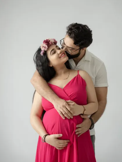 A warm and affectionate embrace. This close-up shot beautifully captures the love and intimacy between the expecting couple.