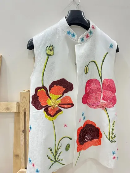 This piece combines hand-painting with hand-work. I painted these vibrant poppies on a white vest and then added sequin embellishments to the center of the flowers for an extra touch of sparkle.