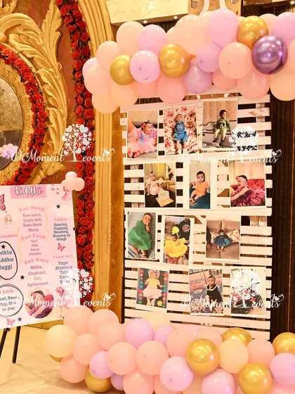 A rustic wooden pallet is used to display first-year photos, complemented by a personalized milestone poster for a butterfly-themed party.