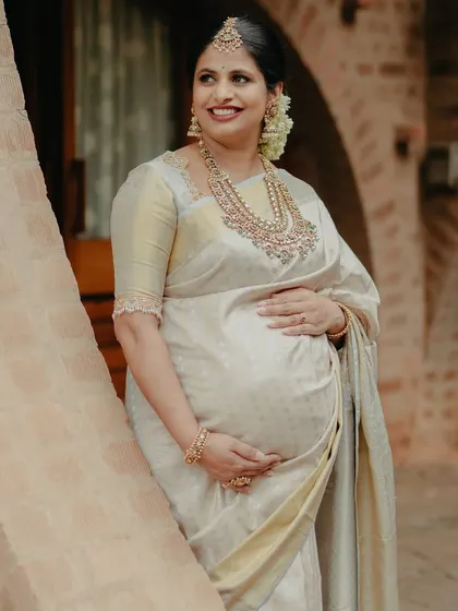 A joyful portrait, her hand on her baby bump, her smile full of love and anticipation.