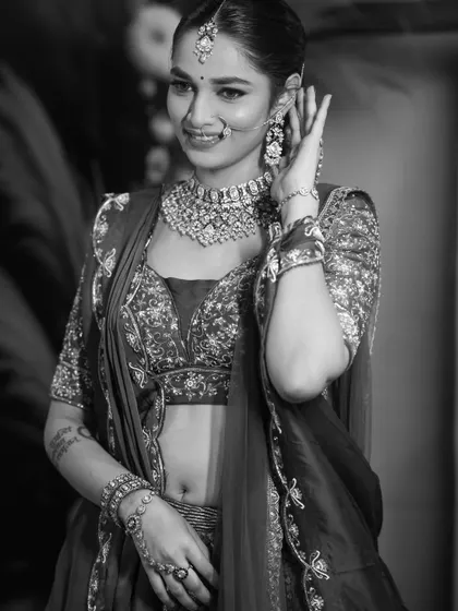 A candid, smiling black and white shot. Converting to monochrome brings attention to the bride's expression and the texture of the intricate beadwork on her outfit.