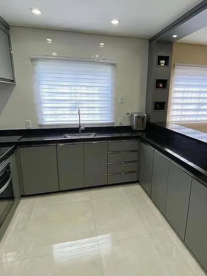 A comprehensive view of the U-shaped kitchen layout, highlighting the ample counter space and storage. The reflective finish on the grey cabinets helps to make the space feel larger.