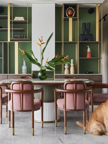 Another view of the pet-friendly dining space in the "Whimsical House." The combination of the green shelving, pink chairs, and marble table creates a playful yet elegant atmosphere.