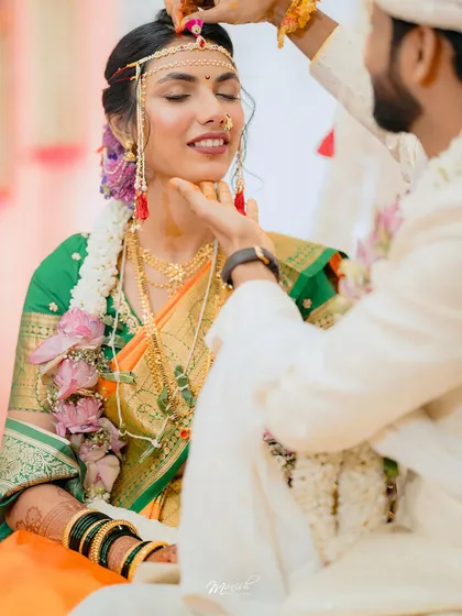 A tender moment during the engagement ceremony, as the groom lovingly touches the bride's chin.
