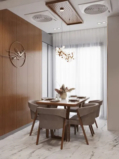 A compact and stylish dining space featuring a square table and a striking bird-like chandelier. The wood-paneled wall adds warmth, while the marble-finish floor provides a touch of luxury.
