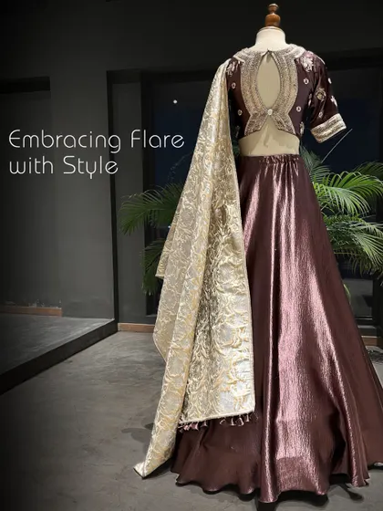 Embracing flare with style. The back of this brown lehenga reveals a stunning keyhole design on the blouse, adding a touch of modern sophistication.