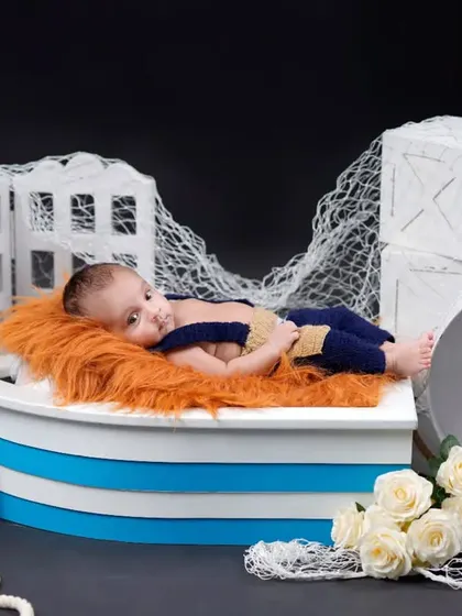 Ahoy, little sailor. This nautical-themed studio setup with a boat prop and anchor detail is perfect for your little adventurer.