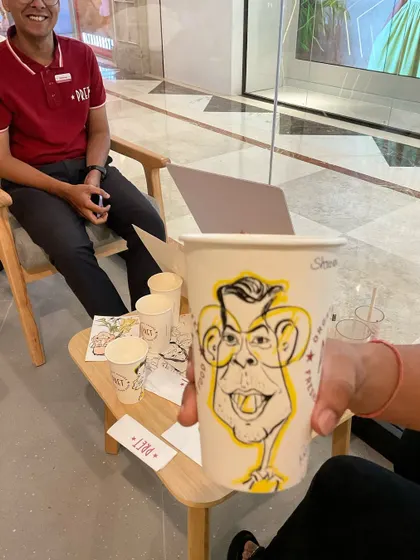 A close-up of a caricature drawn on a Pret coffee cup, a fun and innovative branding collaboration.