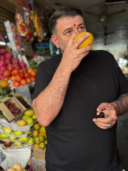 A moment of discovery. Chef Guram smells a fresh mango at a local market, immersing himself in the scents and flavours of India that will inspire his culinary creations during his pop-up tour.