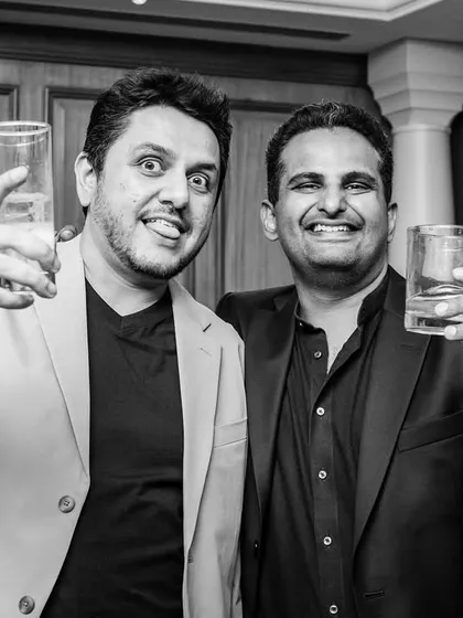 A black and white shot of two guests toasting to the couple. Even in monochrome, the celebratory mood is perfectly clear.