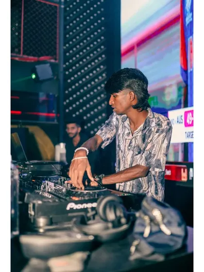 A side angle of me working the mixer, with my headphones on. This is a classic DJ pose that shows intense focus.
