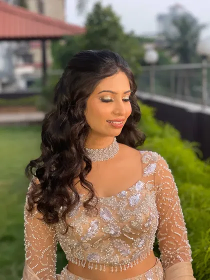Dazzling and glamorous for her sangeet night. The golden eye makeup and sparkling diamond choker are perfectly balanced by soft, flowing waves, creating a look of pure sophistication.