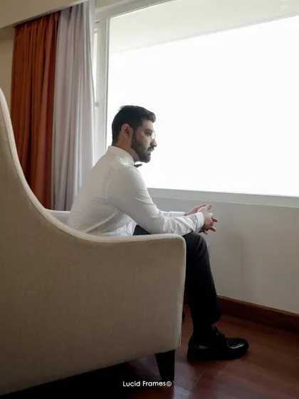 A contemplative portrait of the groom looking out the window, moments before the ceremony.
