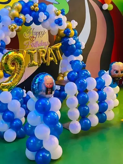 A Boss Baby themed birthday decoration with a blue, white, and gold balloon arch. The setup includes character foil balloons and a large number "9" foil balloon, perfect for a stylish and fun party.