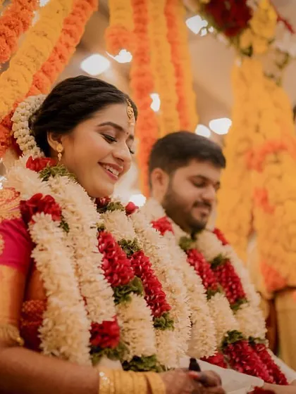 A candid shot of the bride smiling as she participates in the wedding rituals on the swing.