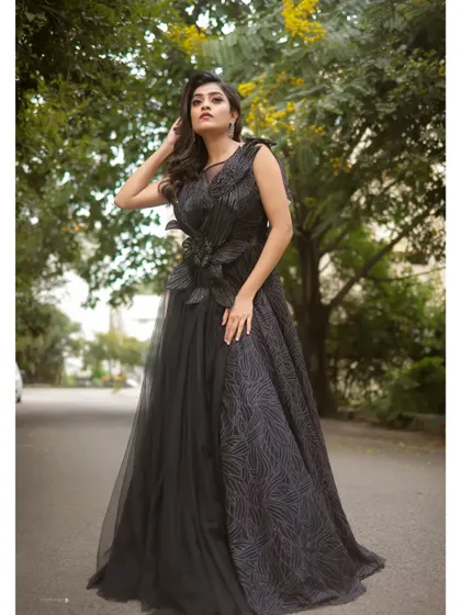The combination of textures in this black gown, from the sheer netting to the detailed bodice, creates a look of pure sophistication.