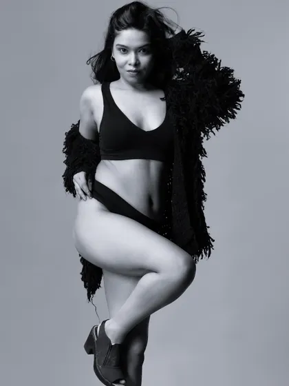 A black and white portrait of a model in a lingerie set, with a classic and strong pose.