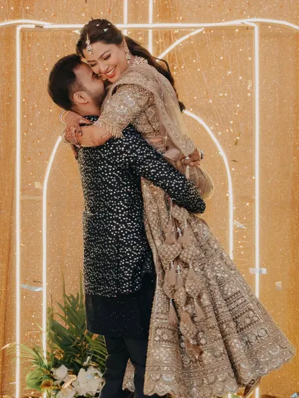 A joyful moment as the groom lifts the bride in a happy embrace during their engagement celebration.