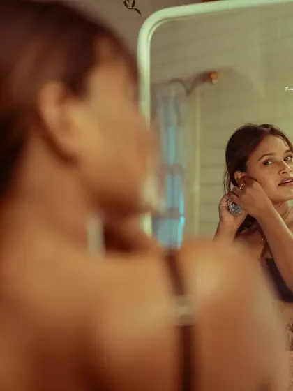 A close-up reflection shot, capturing the act of getting ready. This adds a narrative element to a simple portrait.