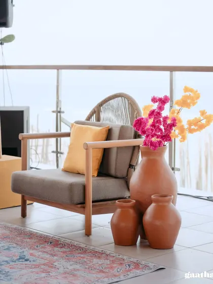 Terracotta vases with bright pink and yellow flowers add a rustic yet vibrant touch to the modern decor.
