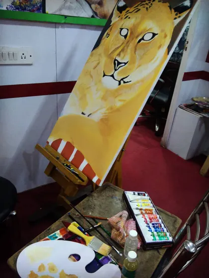 My work studio during the creation of the leopard oil painting. This raw photo shows the canvas on the easel, my palette, and the organized chaos of my creative space.