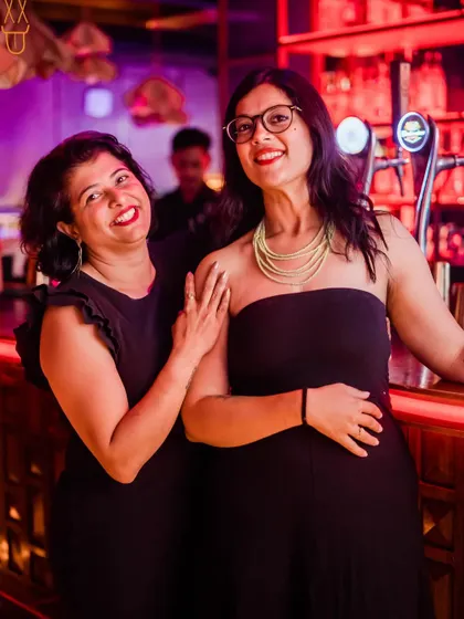 Another shot of two friends enjoying the warm, inviting atmosphere of the bar area.