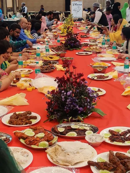 Guests gathered at a beautifully decorated groom's table at CM Palace. The table is filled with our signature dishes, from fish starters to various chicken preparations, creating a vibrant and festive atmosphere.