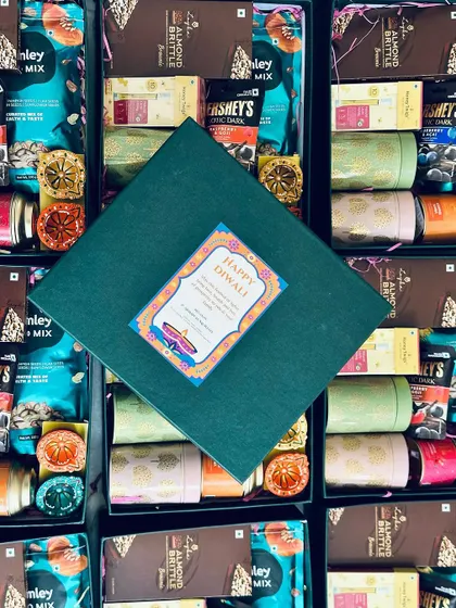 A top-down view of a closed hamper, perfectly centered among the open boxes, showing both the beautiful exterior and the tempting interior.