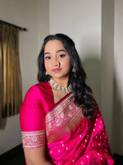 A classic engagement portrait. The bride's makeup is elegant and timeless, perfectly complementing her traditional attire and jewelry.