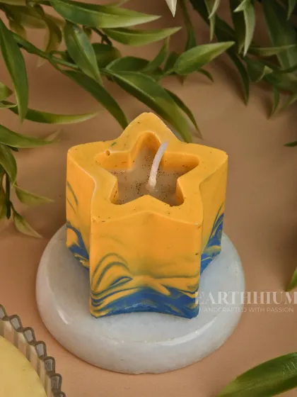 This star-shaped Jesmonite candle has a playful blue and yellow marble design. It's a fun and cheerful piece that adds a pop of color to any space.
