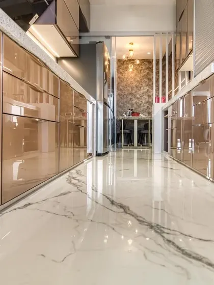 A low-angle shot of the back-painted glass cabinets, reflecting the marble flooring and creating a sense of luxury.