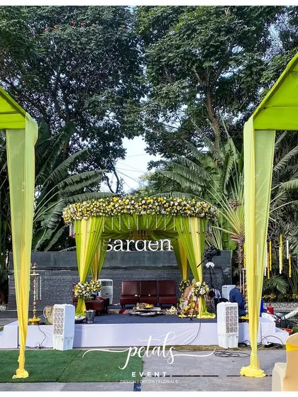This Telugu wedding mandap combines vibrant color with tradition. I used drapes of light green and yellow fabric to create a festive canopy, with a dense floral border of yellow and white flowers framing the sacred space.