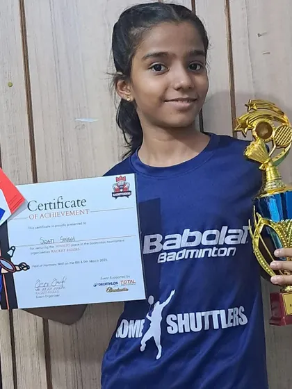 Swati, wearing her Home Shuttlers jersey, holds her trophy and certificate after securing the Under-15 title. We provide our players with quality gear and a strong team identity.