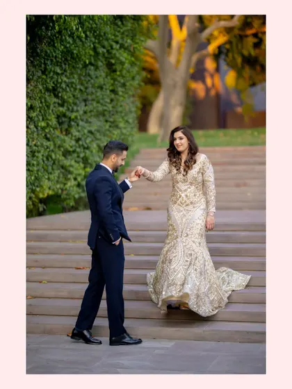 John leads Jahanvi down the steps at The Roseate, Gurgaon. Her golden gown shimmers in the evening light, creating a fairytale moment of pure elegance and charm.