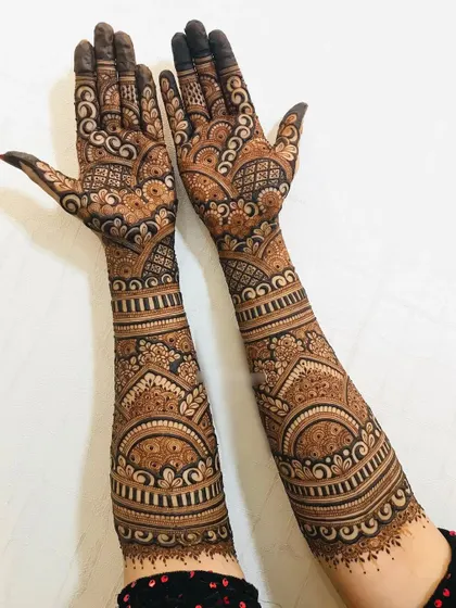 A full-arm bridal design with dense, intricate patterns. This style ensures a very dark and rich henna stain.