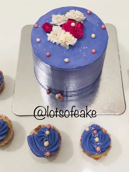I love creating matching sets for celebrations. Here is a vanilla blueberry cake with a beautiful purple whipped cream frosting, accompanied by matching vanilla cupcakes for a complete party spread.