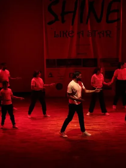 The stage is washed in red light for this dramatic group performance.