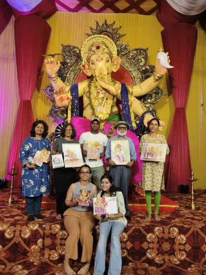 Our group of artists from Suburban Sketchers Mumbai posing with our artwork in front of the magnificent Ganpati idol. Sketching together during the festival is a cherished tradition.