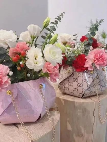 The Pinwheel Waterproof Paper Gift Bag is a stylish and durable packaging solution. These designer-inspired bags, filled with flowers, can also serve as unique party favors or decor elements.