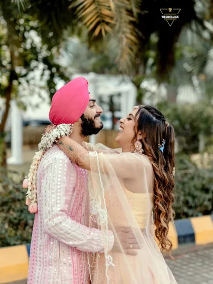 A beautiful, happy moment from an Anand Karaj celebration. Her joyful laugh as she embraces him is infectious. Capturing these genuine emotions is what makes a photograph truly memorable.