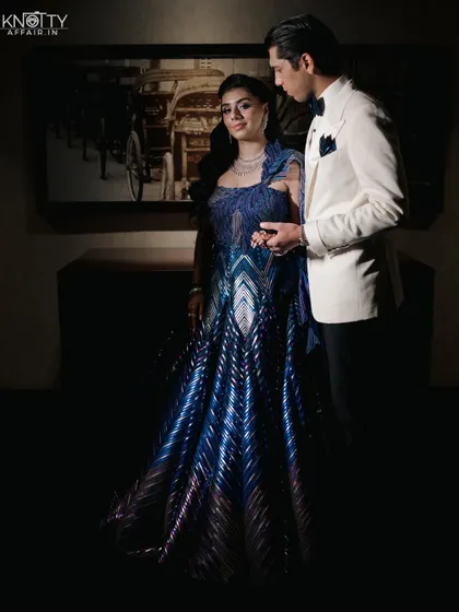 A dramatic, low-light portrait showcasing the bride's stunning blue gown. We are experts at using light and shadow to create striking, fashionable images.