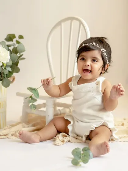 Another adorable shot from this sitter session. Her happy expression and the classic white setup are a perfect combination.