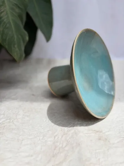 An artistic shot of the elevated plate, highlighting its sleek lines and the beautiful turquoise glaze.