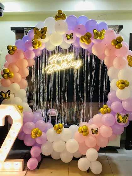 A pretty 2nd birthday balloon ring in pastel pink and purple, with butterfly accents and a light-up number "2".