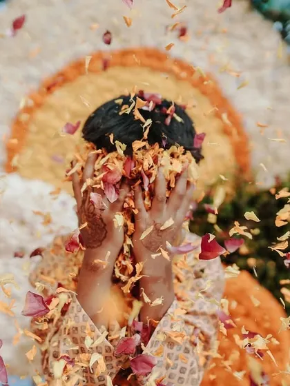 A child playfully hiding their face in a shower of flower petals. It's a moment of pure, uninhibited joy that makes for a stunning and colorful photograph.