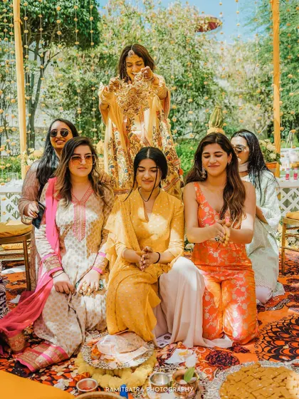 The bride performs the Kaleerey ritual with her bridesmaids sitting in anticipation.