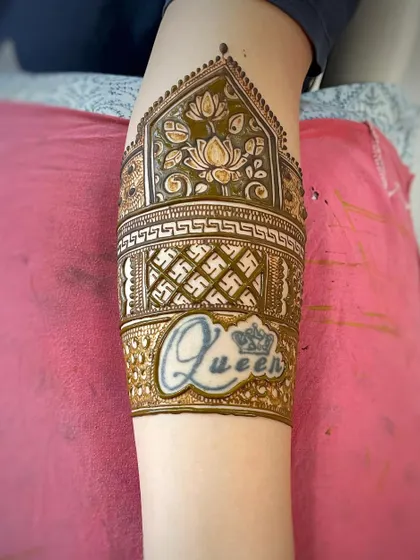 Here I incorporated a client's "Queen" tattoo into the mehndi design. The arm band features lotus motifs and a traditional swastika pattern.
