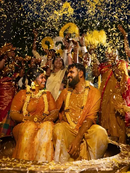 A grand celebration as family and friends shower the couple with flower petals during their Haldi. This shot captures the scale and joy of the event.